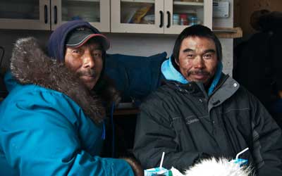 Residents Peter Kattuk (left) and Johnassie Ippak (right) sit together. They are two of the hunters interviewed for the Sanikiluaq Sea Ice Project. Photo credit: Chris McNeave
