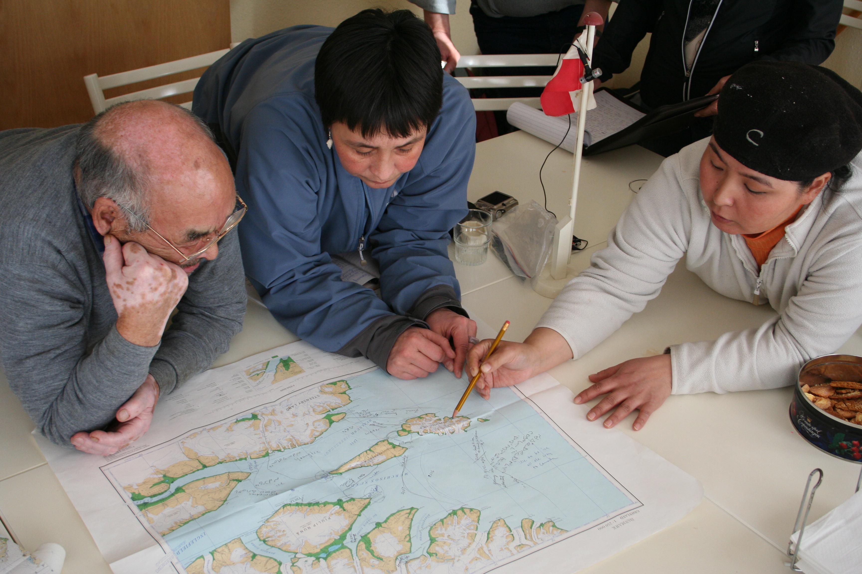 Knowledge holders discuss over map of coastal Alaska